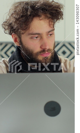 Vertical video. Sick bearded man blows his nose into a paper napkin while working remotely at home. Man feeling unwell, sick with running nose, need a rest. Vertical video. Sick bearded man blows his nose into a paper napkin while working remotely at home. Man feeling unwell, sick with running nose, need a rest. 143098307