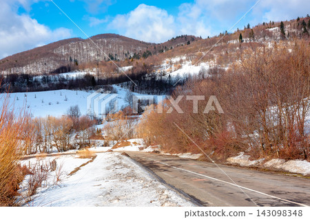 road through Carpathian mountain landscape in winter. travel countryside background. snow covered hills. sunny day road through Carpathian mountain landscape in winter. travel countryside background. snow covered hills. sunny day 143098348