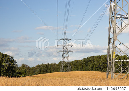 High voltage electricity pylons across rural field High voltage electricity pylons across rural field 143098637