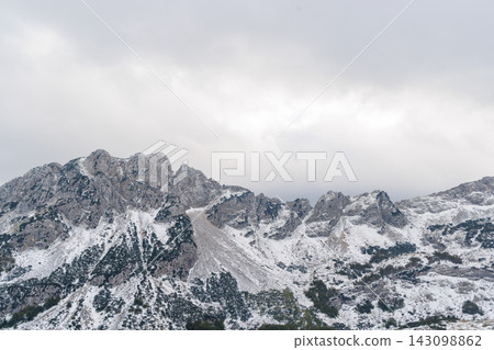 Snow-covered mountains in Montenegro with moody sky Snow-covered mountains in Montenegro with moody sky 143098862