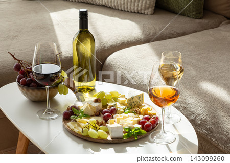 Elegant wine and cheese platter with grapes and artisanal cheese selection for a sophisticated gathering Elegant wine and cheese platter with grapes and artisanal cheese selection for a sophisticated gathering 143099260