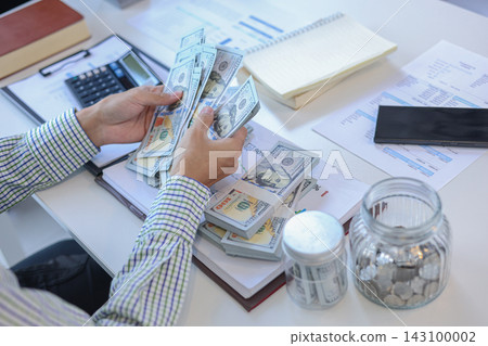 Person Counting US Dollar Bills and Planning Monthly Finance Budget Person Counting US Dollar Bills and Planning Monthly Finance Budget 143100002