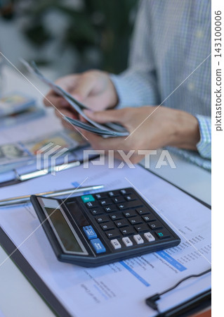Person Counting US Dollar Bills and Planning Monthly Finance Budget Person Counting US Dollar Bills and Planning Monthly Finance Budget 143100006