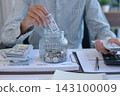 Close Up of Man Saving Money in Glass Container, Concept of Smart Financial Planning and Cash Budgeting Strategy. 143100009