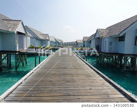 Overwater bungalows, a pier, and the blue sea. Overwater bungalows, a pier, and the blue sea. 143100530