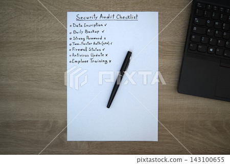 Cybersecurity audit checklist on wooden desk with laptop Cybersecurity audit checklist on wooden desk with laptop 143100655