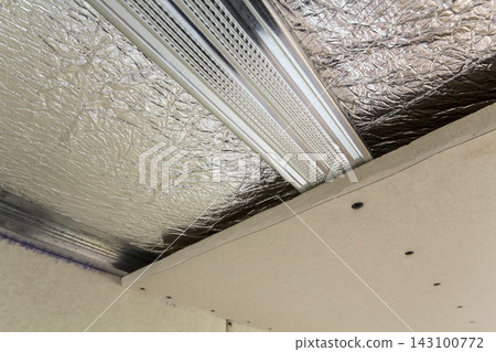 Room under construction with silver aluminum insulation foil and drywall on walls and ceiling. Room under construction with silver aluminum insulation foil and drywall on walls and ceiling. 143100772