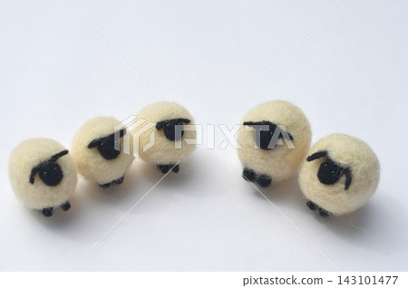 A row of sheep with black faces made of wool felt. A row of sheep with black faces made of wool felt. 143101477