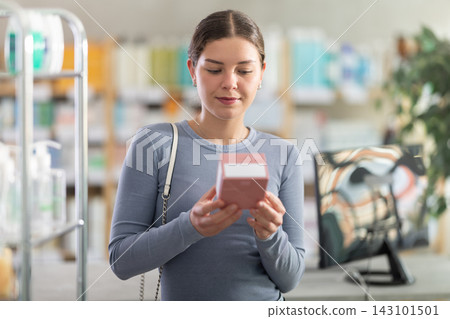Young woman choosing prescribed medication at dispensary counter Young woman choosing prescribed medication at dispensary counter 143101501