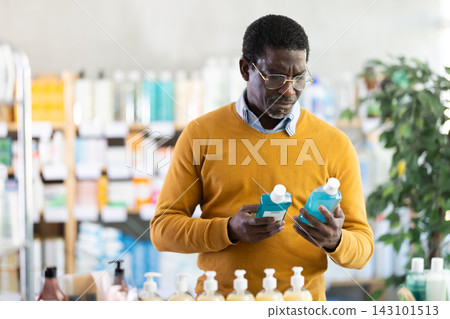 African American man choosing mouthwash at pharmacy African American man choosing mouthwash at pharmacy 143101513