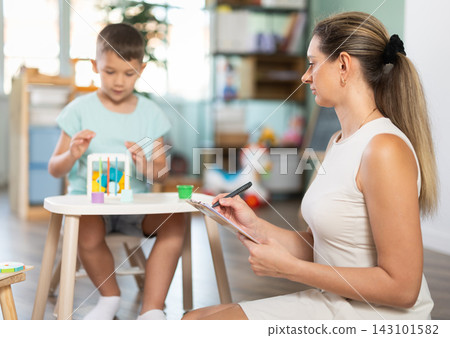 Boy plays with wooden sorter Boy plays with wooden sorter 143101582