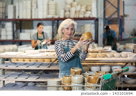 Portrait of positive senior woman potter with bowl Portrait of positive senior woman potter with bowl 143101694
