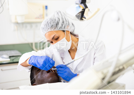 Dentist examining oral cavity of man in dental clinic Dentist examining oral cavity of man in dental clinic 143101894