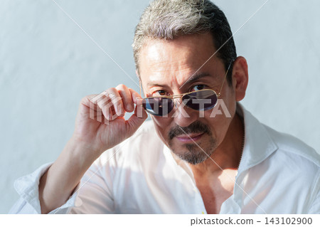 A middle-aged male model wearing sunglasses. A middle-aged male model wearing sunglasses. 143102900