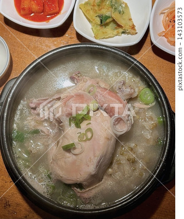 Samgyetang, a hearty Korean ginseng chicken soup, featuring a whole young chicken stuffed with rice, garlic, jujube, and herbs. A nourishing dish perfect for health and comfort. 143103573