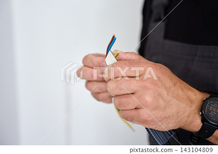 Man preparing electrical wires for installation Man preparing electrical wires for installation 143104809