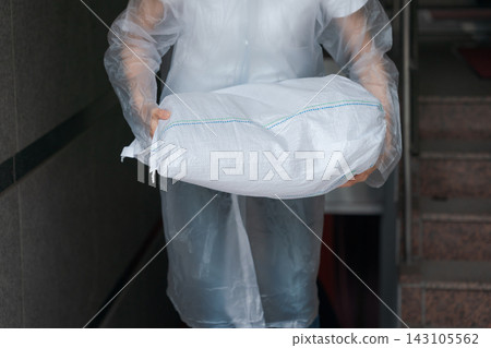 一名婦女正在堆放沙袋,為防洪做準備。 一名婦女正在堆放沙袋,為防洪做準備。 143105562