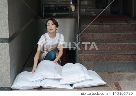 一名婦女正在堆放沙袋，為防洪做準備。 143105730