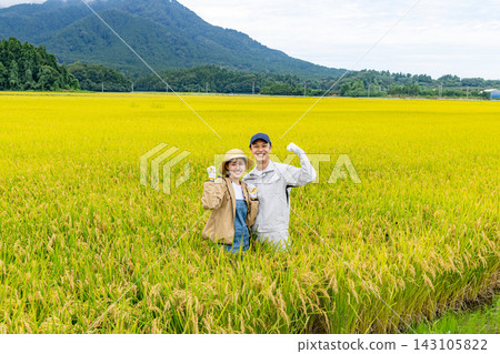A portrait of a couple harvesting rice amidst the rice fields. A portrait of a couple harvesting rice amidst the rice fields. 143105822