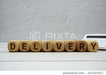 DELIVERY alphabet letters with calculator on wooden background 143105921