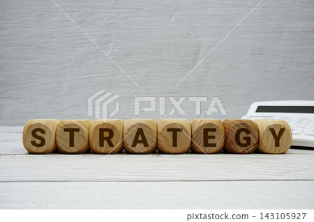 STRATEGY alphabet letters with calculator on wooden background STRATEGY alphabet letters with calculator on wooden background 143105927