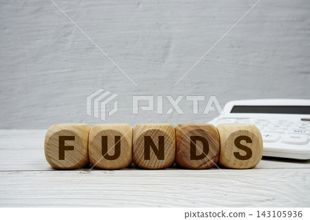 FUNDS alphabet letters with calculator on wooden background FUNDS alphabet letters with calculator on wooden background 143105936