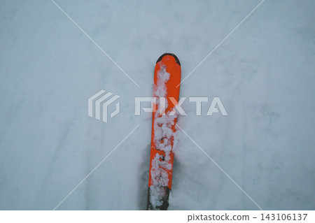 橙色滑雪板的尖端覆蓋著積雪。 143106137