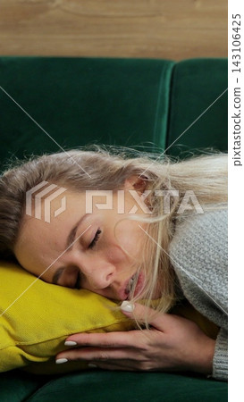 Vertical video. Bored woman rests on sofa, sleeping at home. Vertical video. Bored woman rests on sofa, sleeping at home. 143106425