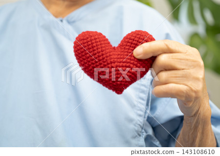 Asian senior patient woman holding red heart for health in hospital. Asian senior patient woman holding red heart for health in hospital. 143108610