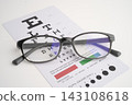 Glasses on eye testing exam chart to check eyesight accuracy of reading. 143108618