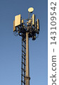 Close-up of tall telecommunication tower and 5G cellular antennas against a clear blue sky. 143109542