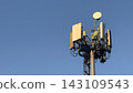 Close-up of tall telecommunication tower and 5G cellular antennas against a clear blue sky. 143109543