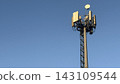 Close-up of tall telecommunication tower and 5G cellular antennas against a clear blue sky. 143109544