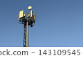 Close-up of tall telecommunication tower and 5G cellular antennas against a clear blue sky. 143109545