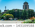 The historic architecture and clock tower of Nagoya City Hall stand out against the blue sky. 143109588
