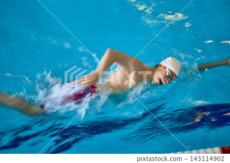 Male swimmer performing freestyle stroke during pool training. Male swimmer performing freestyle stroke during pool training. 143114902