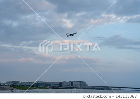 飛機飛越羽田機場和海濱上空 143115368