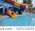 Outdoor swimming pool featuring colorful water slides 143115639