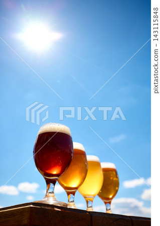 Red amber and golden craft beers in glasses under clear blue sky. Red amber and golden craft beers in glasses under clear blue sky. 143115848
