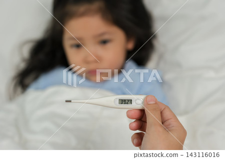 digital thermometer showing temperature of sick child with high fever in bed digital thermometer showing temperature of sick child with high fever in bed 143116016