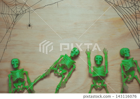 Green Skeleton Toys on Wooden Surface with Spider Webs 143116076