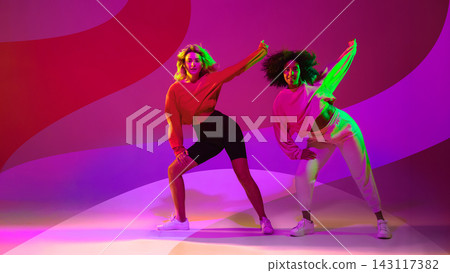 Diverse young dance duo performing against bold magenta background Diverse young dance duo performing against bold magenta background 143117382