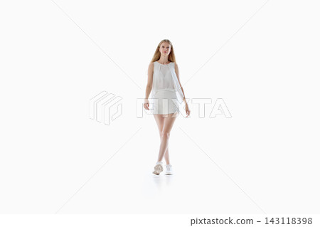 Young woman in white summer outfit walking toward camera on studio background Young woman in white summer outfit walking toward camera on studio background 143118398