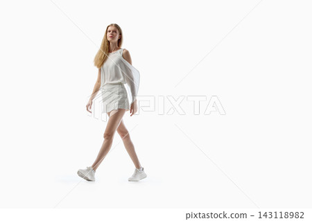 Young woman walking confidently in casual white outfit on studio background Young woman walking confidently in casual white outfit on studio background 143118982