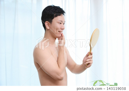 A man notices the effects of facial hair removal in the mirror. A man notices the effects of facial hair removal in the mirror. 143119038