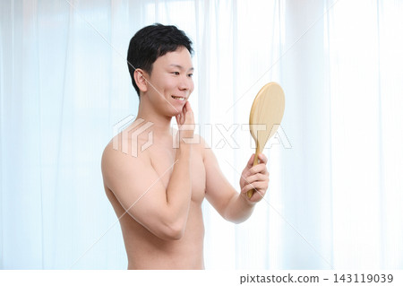 A man notices the effects of facial hair removal in the mirror. A man notices the effects of facial hair removal in the mirror. 143119039