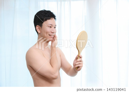 A man notices the effects of facial hair removal in the mirror. A man notices the effects of facial hair removal in the mirror. 143119041