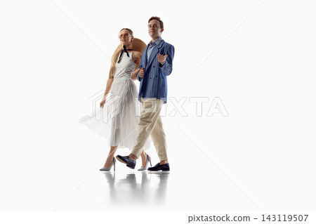 Stylish couple walks together in coordinated light summer outfits Stylish couple walks together in coordinated light summer outfits 143119507