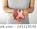 Middle Age Caucasian Woman Holding Pink Ribbon for Breast Cancer Awareness 143119539
