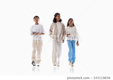 Three young friends walking together in casual outfits on white background Three young friends walking together in casual outfits on white background 143119636